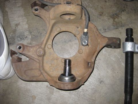 1995 Ford Bronco - A rusty suspension knuckle with a ball joint and sensor is shown with a ball joint press tool.