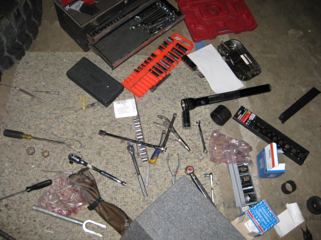 Tools and ball joint parts scattered on garage floor
