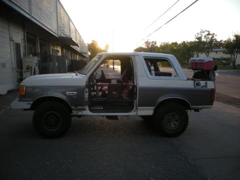 1991 Ford Bronco - Side view of a 1991 Ford Bronco, doors off, with a cooler in the bed.