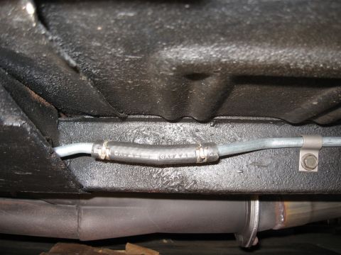 1968 Shelby GT500 - Close-up of a vehicle's fuel line, showing a section of rubber hose with markings.