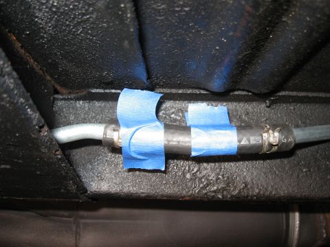 1968 Shelby GT500 - A section of a vehicle's gas line is temporarily secured with blue painter's tape, with a hose clamp visible.
