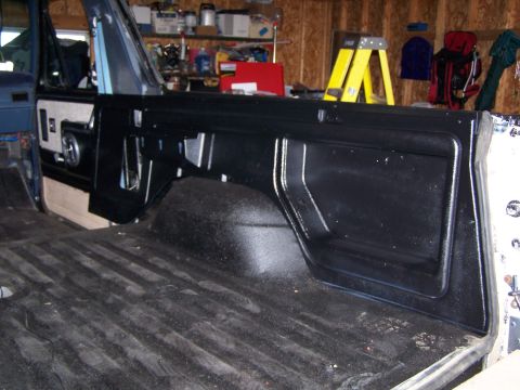 1986 Ford Bronco - Vehicle interior with focus on the rear cargo area and side panel.