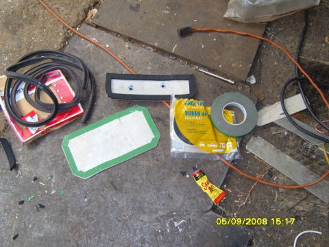 1989 Ford Bronco - A collection of automotive repair and sealing supplies are laid out on a concrete surface. Items include rubber trim, adhesive tape, and a…