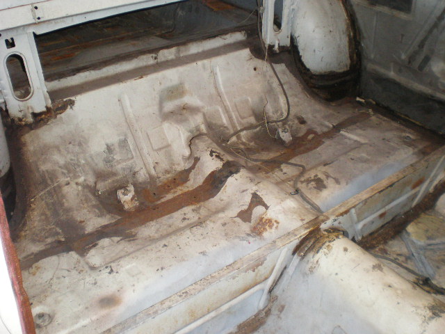 Close-up of a rusty car interior floor pan.
