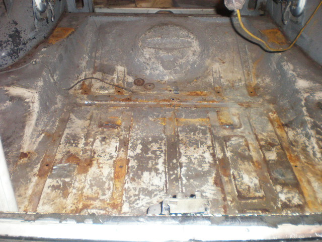 Rusted out rear cargo floor of a classic car.