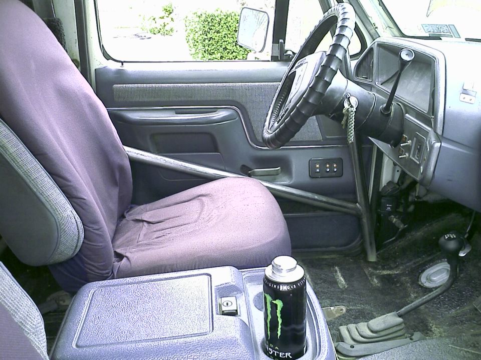 Interior of a 1990 Ford Bronco with a Monster Energy drink can in the console.