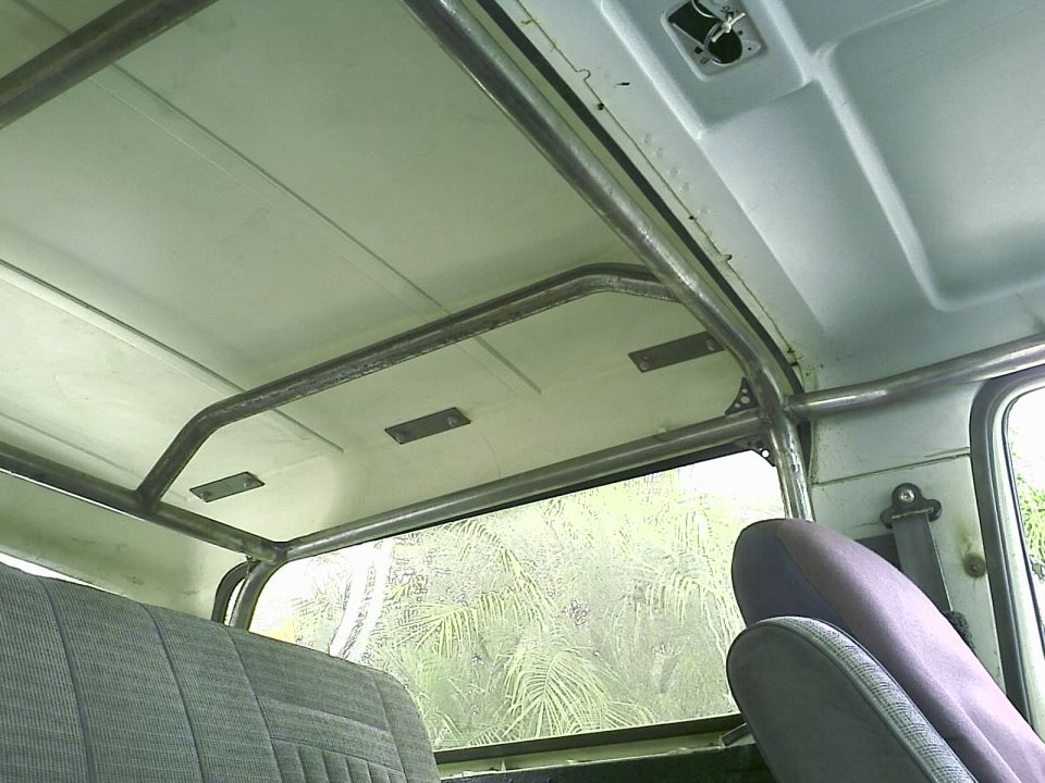 Interior of a 1990 Ford Bronco with a roll cage and rear window view.