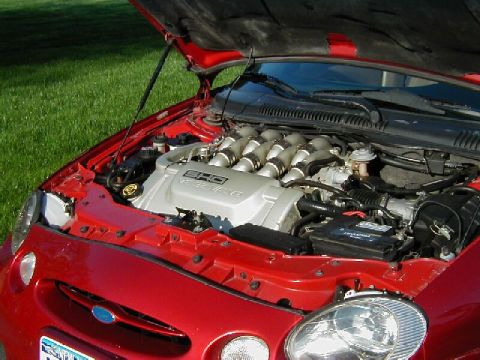 1997 Ford Taurus - The V8 engine of a red Ford Taurus SHO is visible with the hood open.