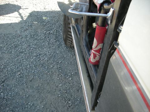 1991 Ford Bronco - Close-up side view of a 1991 Ford Bronco, highlighting the rear fender and a red shock absorber cover with a white pattern.