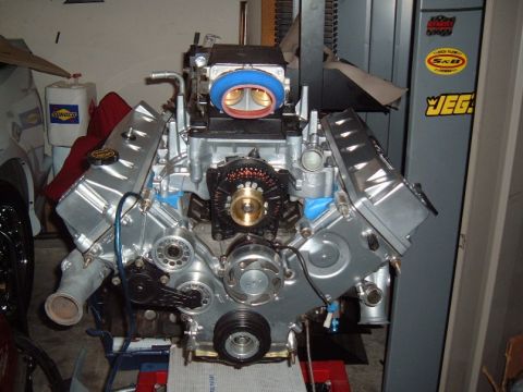 2007 Ford Mustang - A V8 engine, likely modified, is displayed on a stand in a garage setting.
