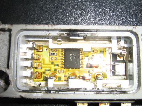 1990 Ford Bronco - Close-up of an electronic control unit's internal circuitry, showing a central black chip and various electronic components.