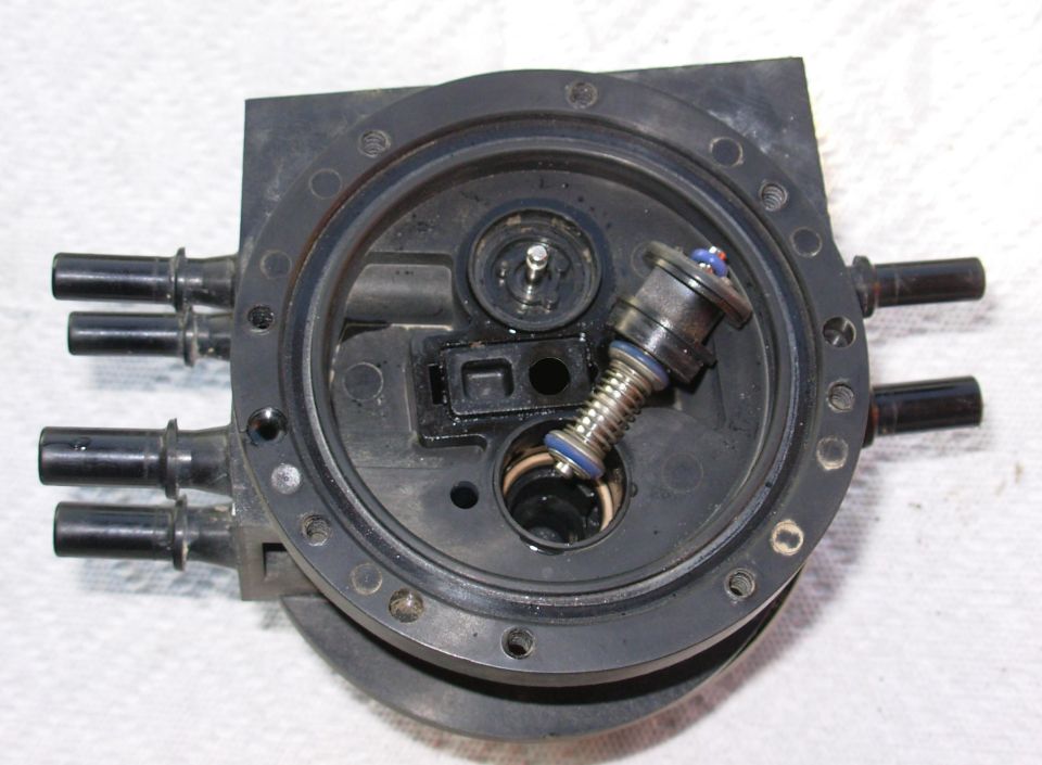 Dual Function Reservoir Switching Valve

Noting their orientations, extract each valve from its bore.  If they remain, carefully remove the white O-rings without distorting them.

The valves must be reinstalled facing the correct direction.