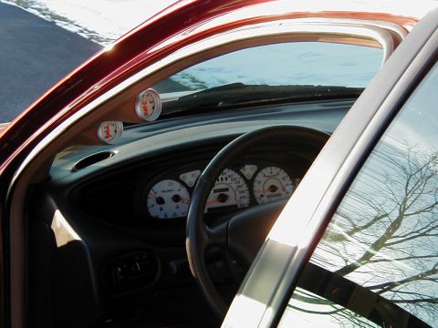 1997 Ford Taurus - Aftermarket gauges are mounted on the A-pillar of this car's interior, which also features white-faced dashboard gauges.