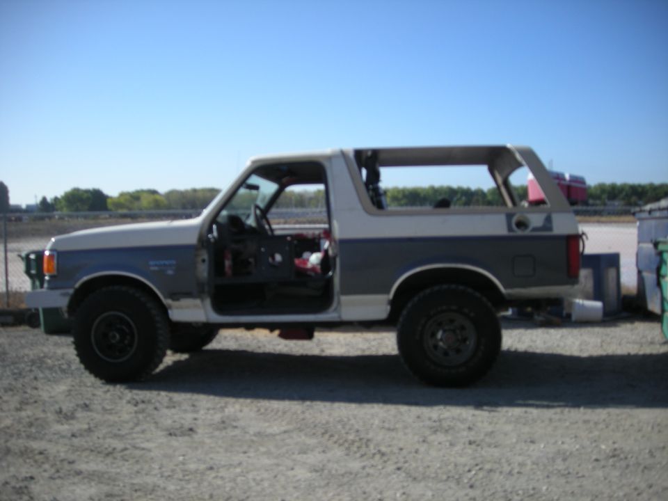 Side view of a two-tone 1991 Ford Bronco with doors removed