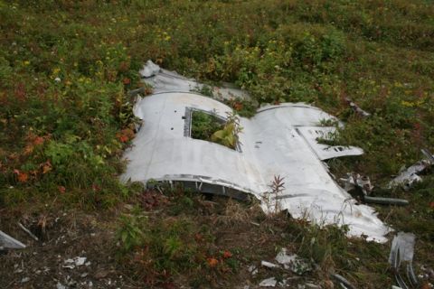 1990 Chevrolet Suburban - A piece of white paper is visible on the ground, partially obscured by grass.