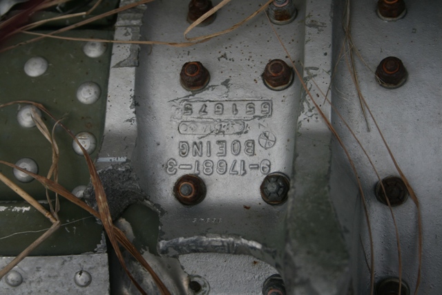 Close-up of a metal aircraft part with Boeing markings and part numbers.