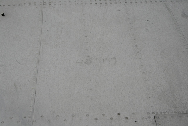 Metal panel with handwritten number 48 4149 and rivets.