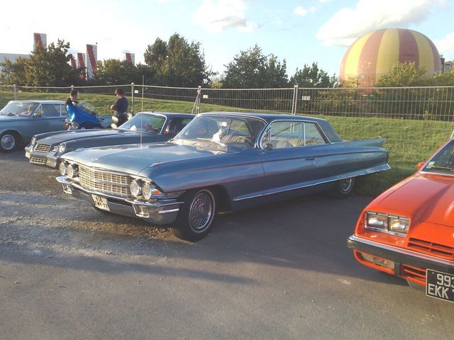 Blue early-1960s Cadillac parked at an outdoor car event