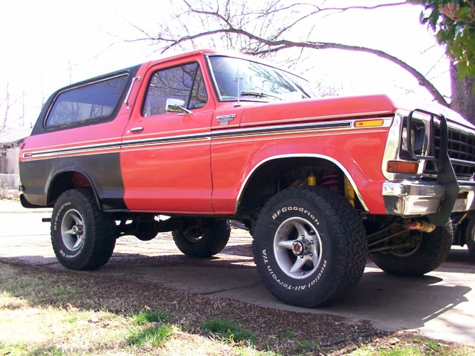 Lifted red and black 1978-1979 Ford Bronco on BFGoodrich tires in driveway