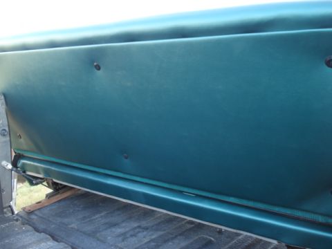 1979 Ford F-150 - The interior of a vintage pickup truck shows a teal vinyl seat back with visible fasteners. The seat is installed in the cab of the truck,…