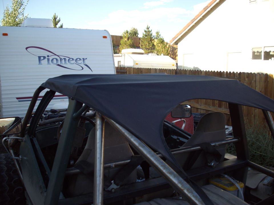 Black fabric soft top stretched over the tube roll cage of an open trail rig