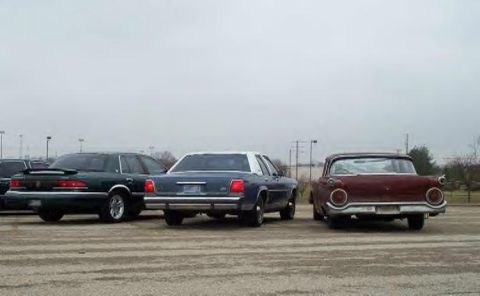 1988 Ford Crown Victoria - Three sedans are parked in an overcast lot, with the rear of a maroon 1957 Ford Fairlane 500 prominently displayed.