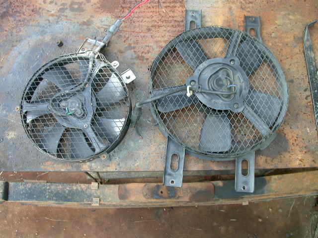 Brutal over heating when running around in low range all day has forced me to take drastic cooling measures, so off came the grill and in went pusher fans to augment the stock mechanical fan.  I nearly bought the $65 parts store fan, then thought better of it and pulled these two out of the pull a part for less than $20.
