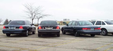 1988 Ford Crown Victoria - Multiple Ford Crown Victoria sedans are parked in an outdoor lot under an overcast sky.