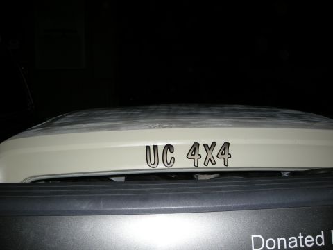 1991 Ford Bronco - The hood of a vehicle displays 'UC 4X4' decals. A portion of the grille is visible underneath.