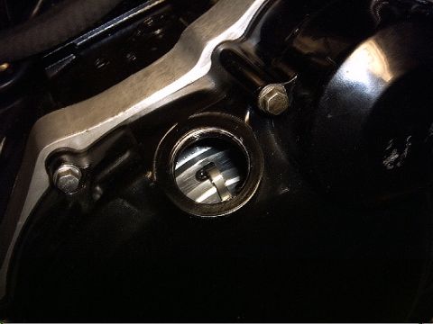 1999 Kawasaki H2C - Close-up view of a motorcycle engine's oil sight glass and surrounding casing.