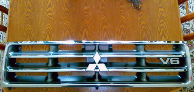 Front grille with Mitsubishi logo and V6 badge. 2000 Mitsubishi Montero part