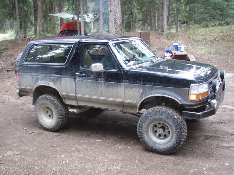 1992 Ford Bronco - This 1992 Ford Bronco is seen at a campsite with tents and trees in the background.
