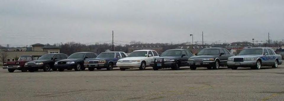 Lineup of Ford Crown Victoria and Lincoln sedans parked side by side at a club meet