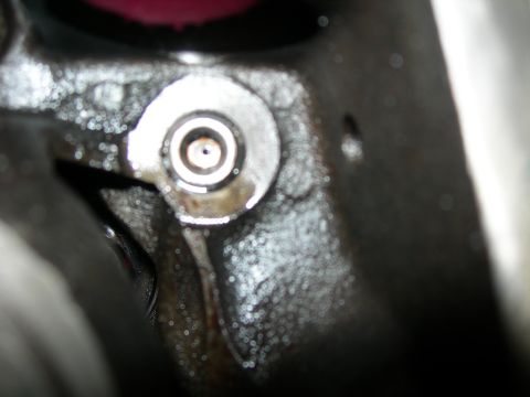 1984 Ford Bronco - A close-up view of a metal component, possibly from an engine, showing a circular fitting with concentric rings and signs of oil or grease.