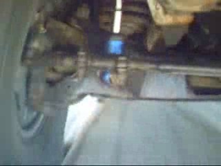 1984 Ford Bronco - Underside view of a vehicle's suspension system, showing a metal bar and blue glowing components. The image appears to be taken from below,…