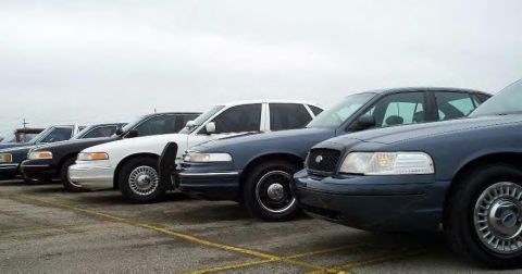 1988 Ford Crown Victoria - Several Ford Crown Victoria police cars are lined up in a parking lot under an overcast sky.