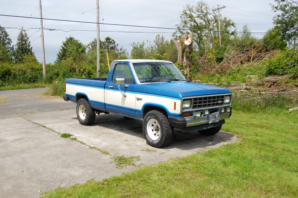Blue and white Ford Ranger pickup truck parked on concrete.