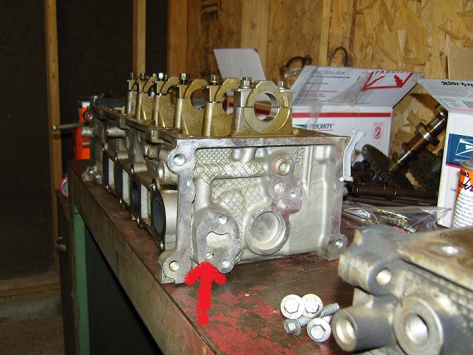 Photo of a cylinder head on a bench with a red arrow callout