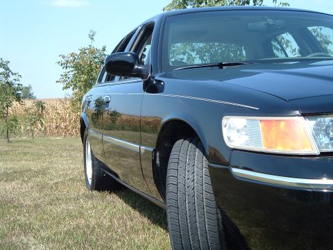 2001 Mercury Grand Marquis - A black 2001 Mercury Grand Marquis is parked on a grassy field with a cornfield and trees in the background. The photo is taken from a low…
