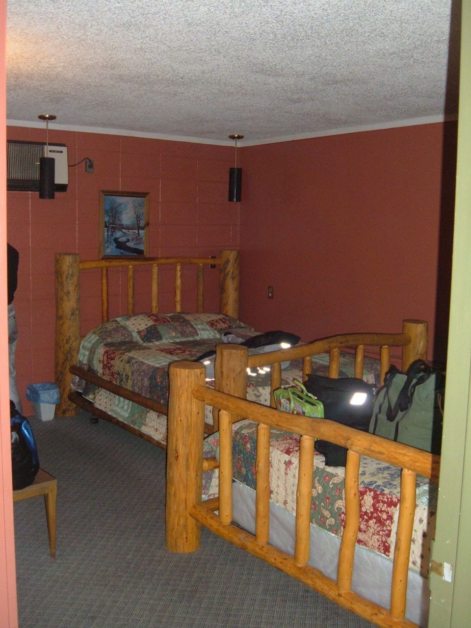 Rustic bedroom with log beds and patchwork quilts.