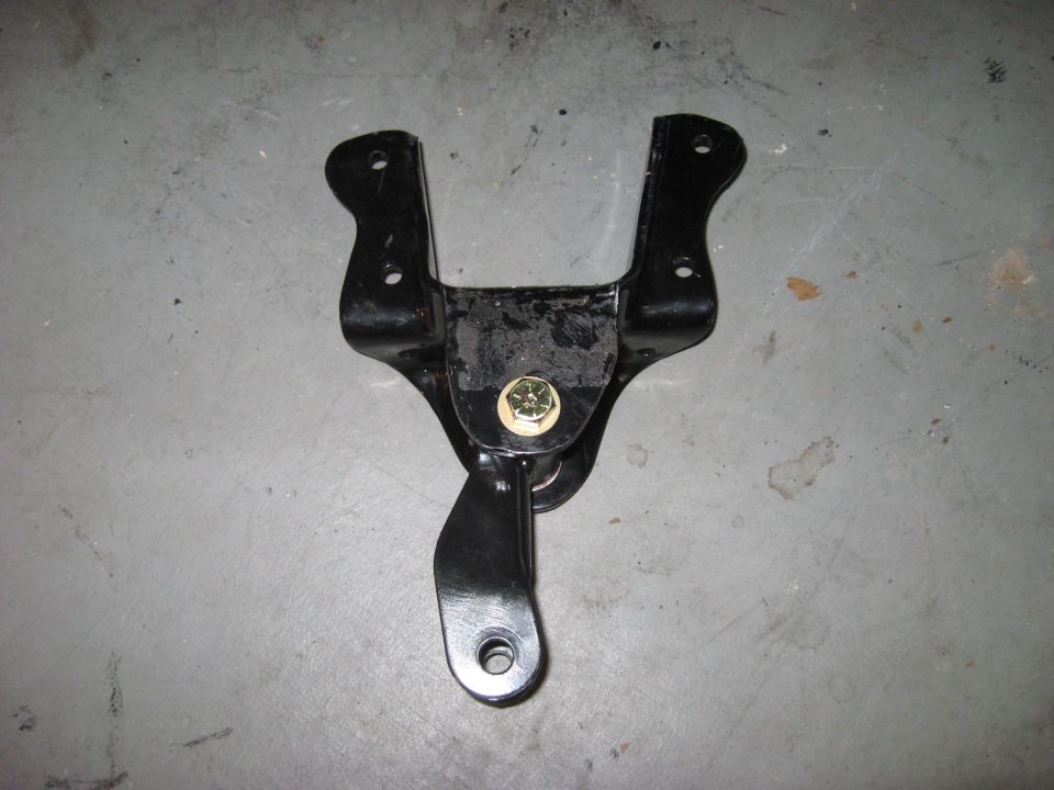 Black metal bracket with bolt and nut on gray concrete floor