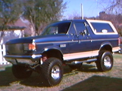 1989 Ford Bronco - This lifted Ford Bronco features a two-tone paint scheme and off-road tires.