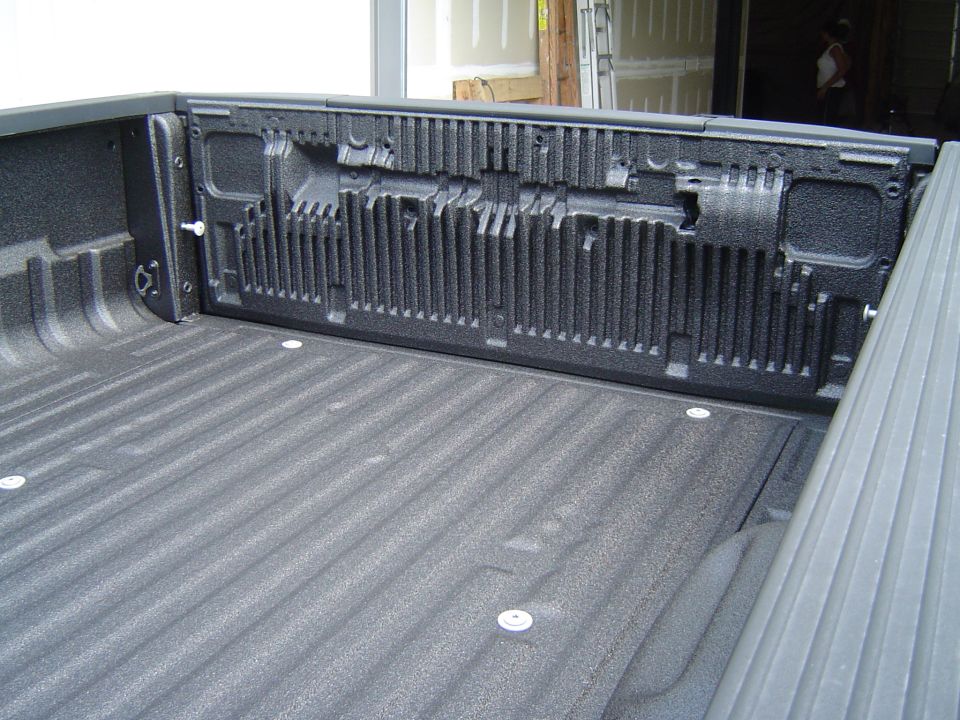 Truck bed with spray-in liner, showing ribbed floor and textured tailgate interior
