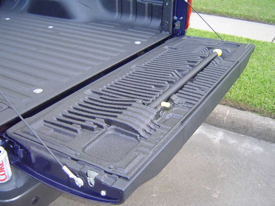 Blue pickup truck tailgate with bedliner and support bar