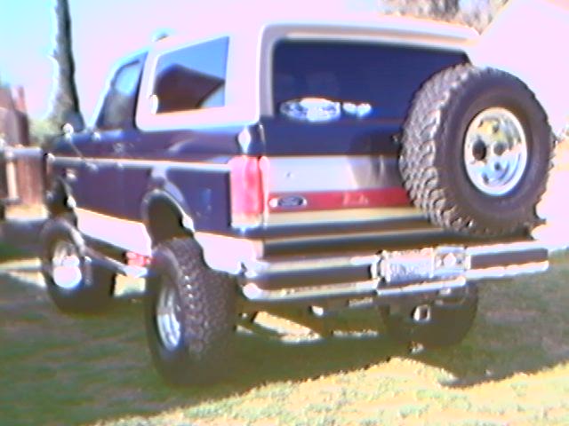 Rear view of blue and tan 1989 Ford Bronco with spare tire
