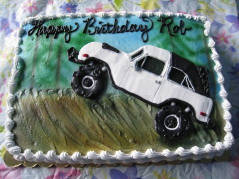 1996 Ford Bronco - A birthday cake features a white off-road vehicle with large tires, set against a green and blue background.