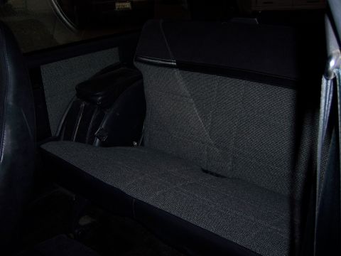 1991 Ford Bronco - The rear interior of a vehicle, showing the seat and side paneling.