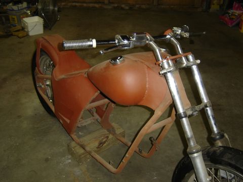 Custom motorcycle frame with rusty gas tank and handlebars