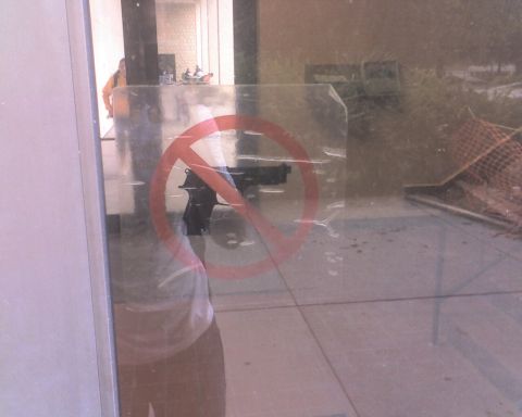1995 Ford Bronco - A no guns allowed symbol is visible on a glass surface, reflecting a person and a firearm.