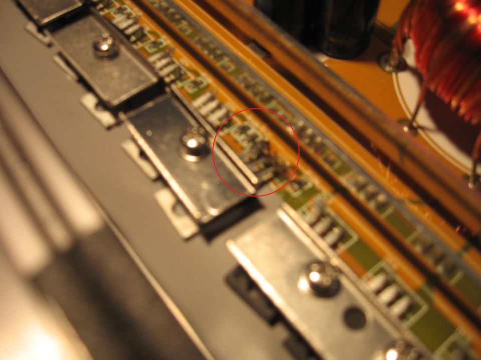 Close-up of an electronic circuit board with a red circle highlighting some components